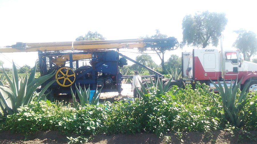 Equipo de perforación trabajando en parcela sembrada de agave